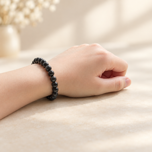 Obsidian bracelet worn on the wrist with a neutral background